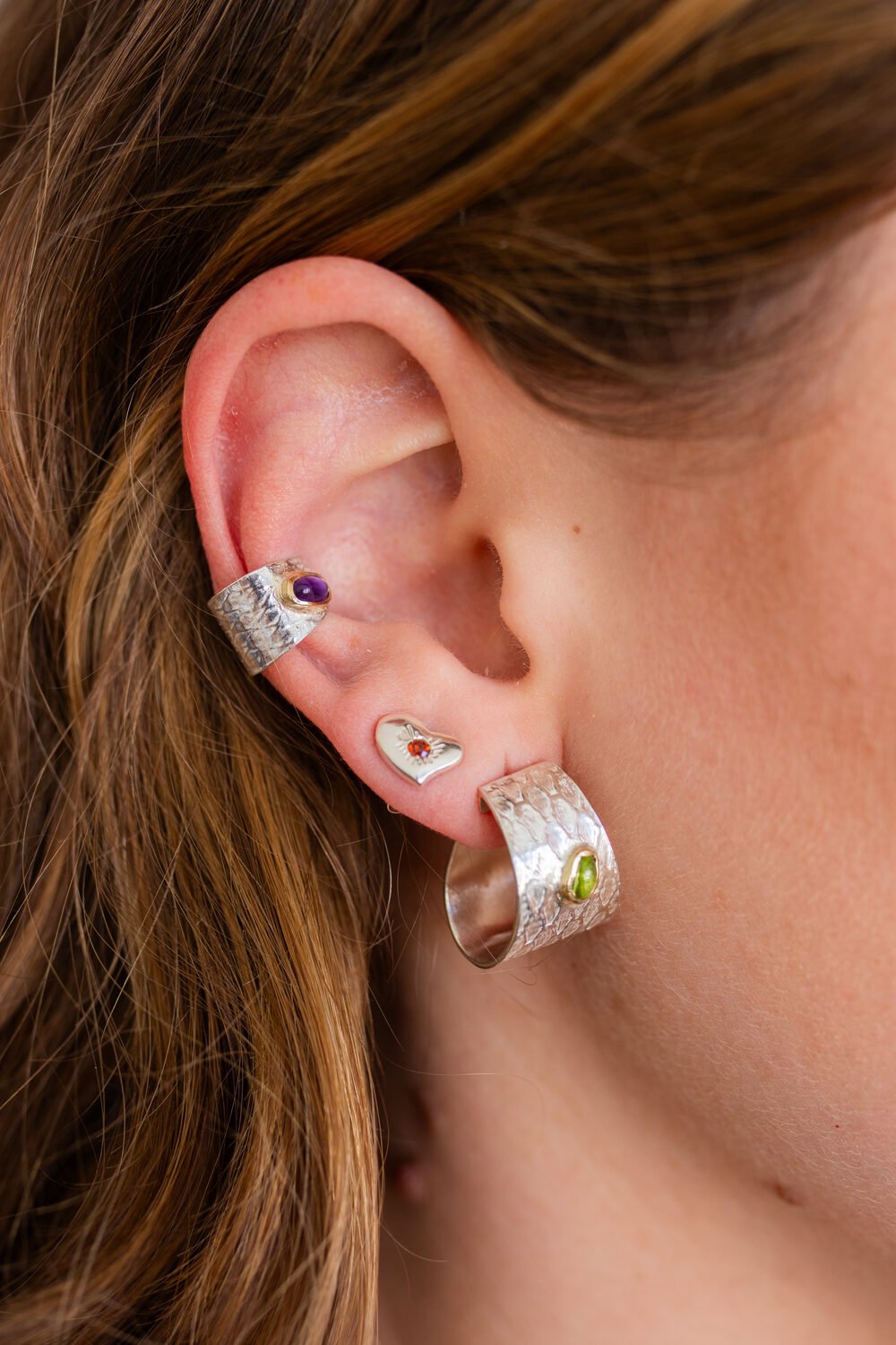 Detalle de oreja con ear cuff y aro grabado