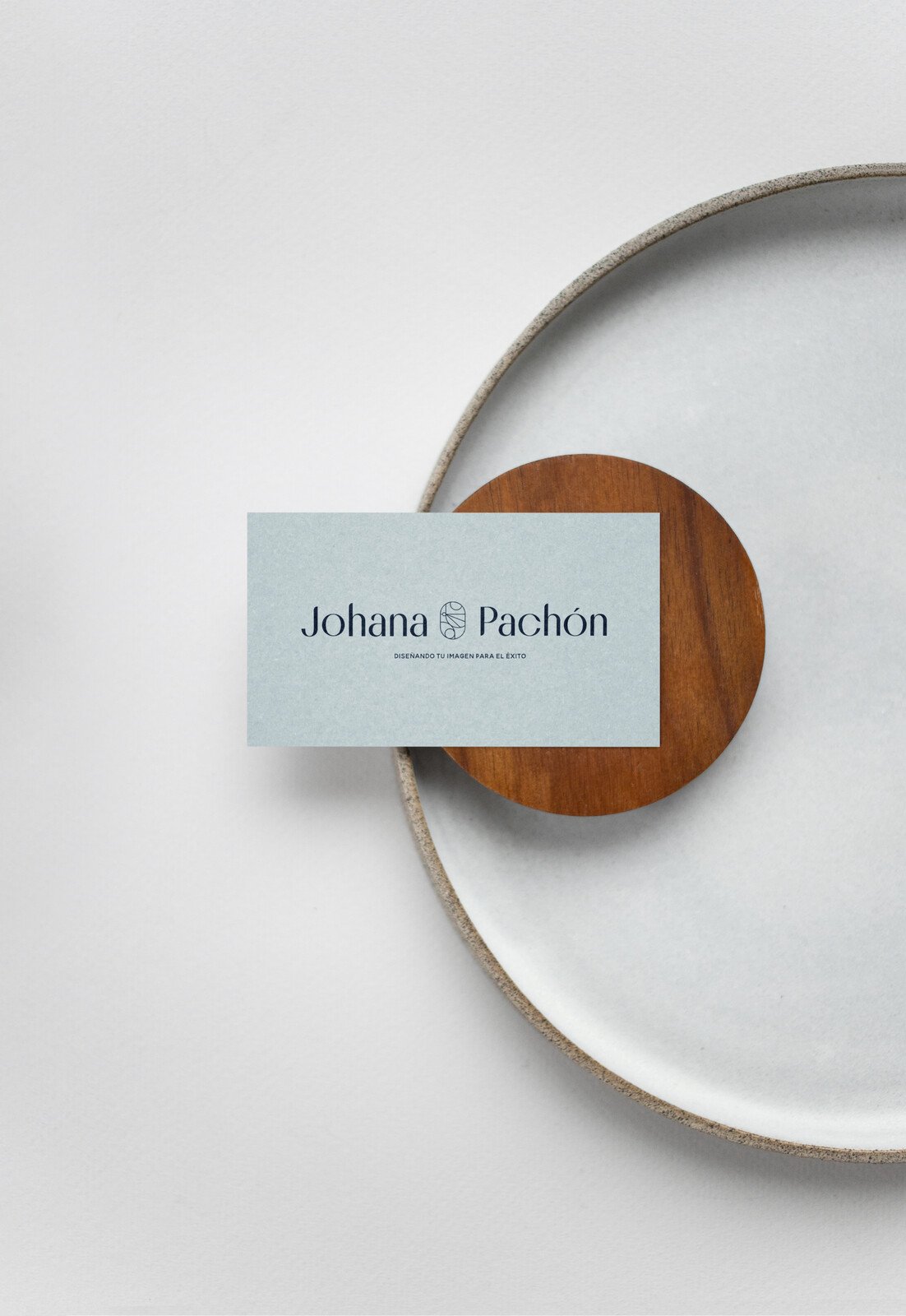 Tarjeta de visita en azul claro sobre un plato de cerámica