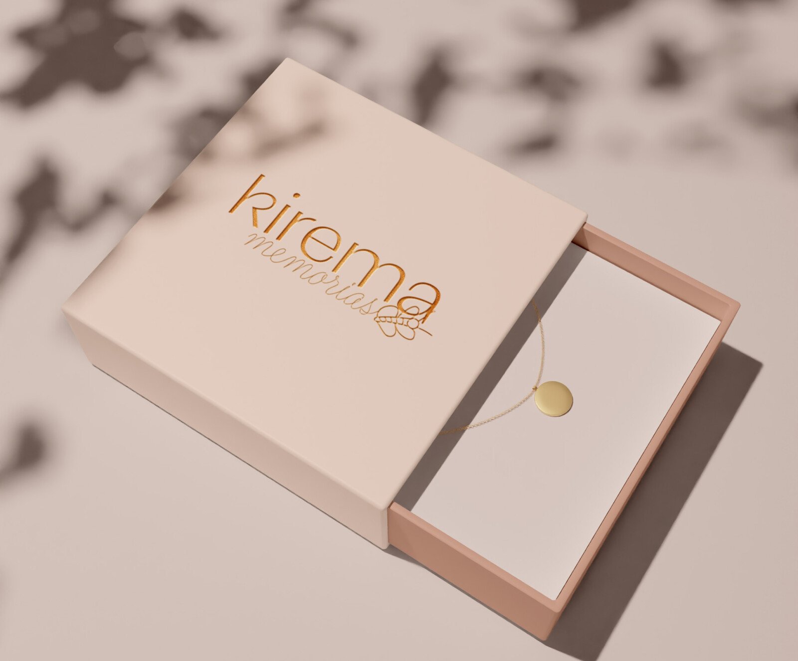 Estuche de joyería en rosa empolvado con un colgante dorado dentro